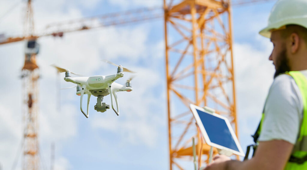 A construction worker operating a drone for aerial mapping purposes